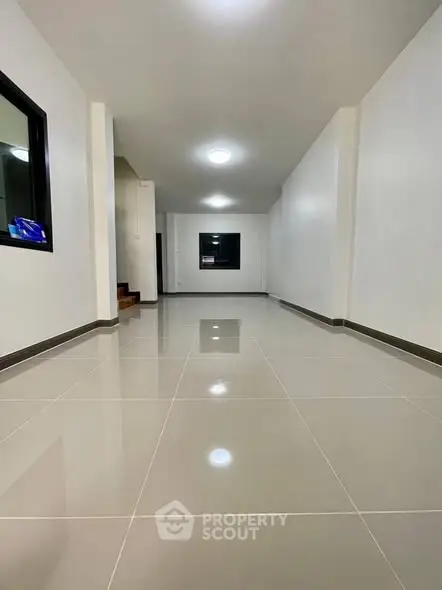 Spacious modern hallway with glossy tiled floors and minimalist design.