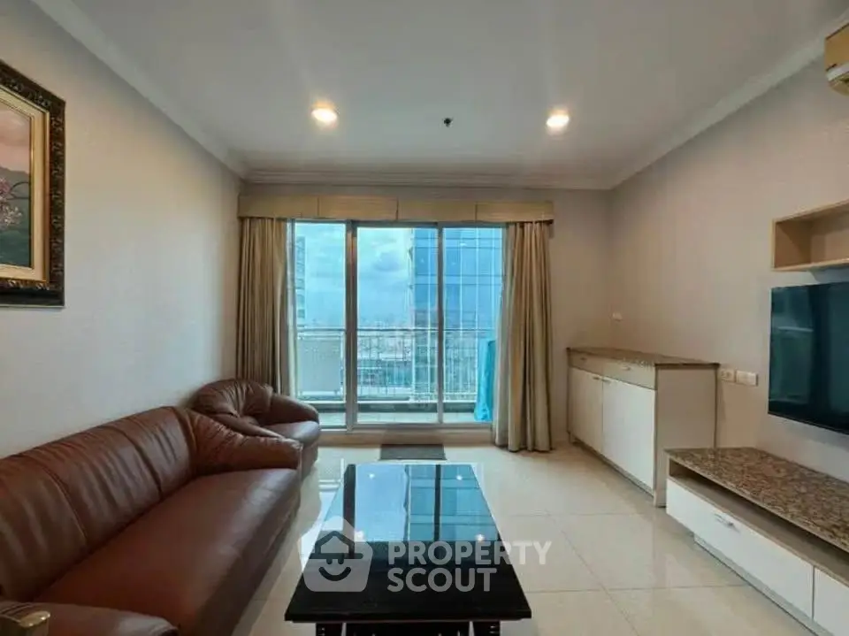 Spacious living room with leather sofa and city view balcony in modern apartment