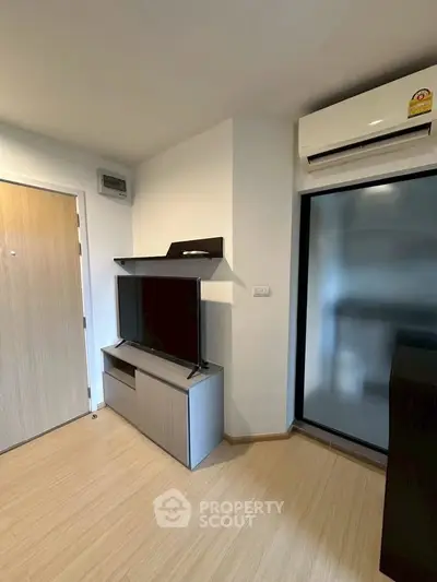 Modern living room with sleek TV stand and air conditioning in a cozy apartment.