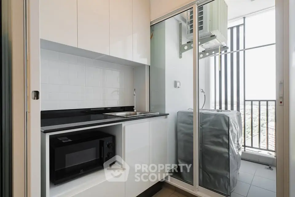 Modern kitchen with sleek cabinetry and balcony view