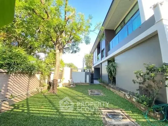 Spacious garden view of modern home with lush greenery and sleek architecture.
