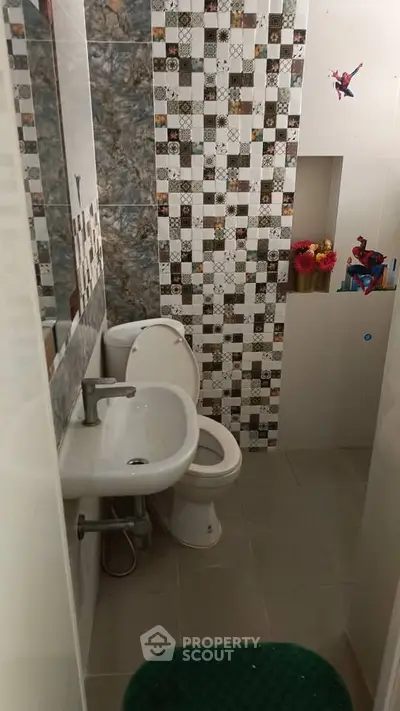 Charming bathroom with unique tile design and modern fixtures.