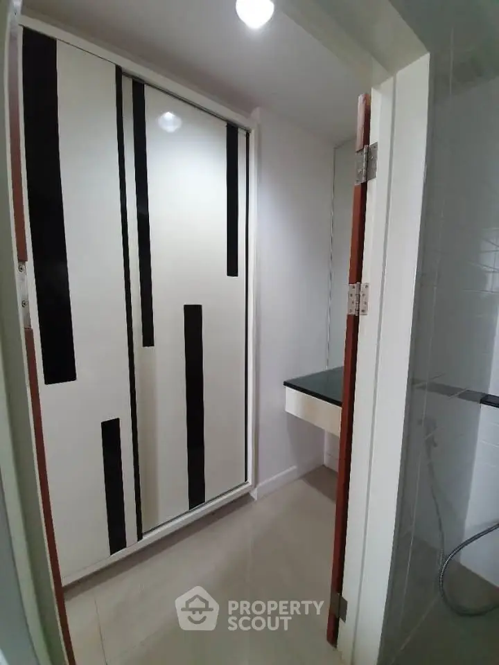 Modern bathroom with sleek black and white design and built-in storage
