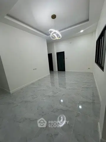 Spacious modern living room with elegant lighting and glossy tiled floor