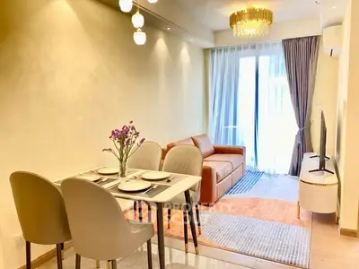 Modern living room with elegant dining area and cozy sofa, featuring stylish lighting and floor-to-ceiling windows.