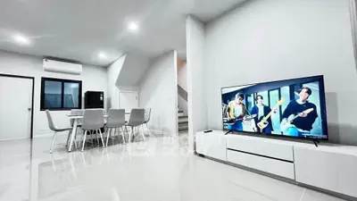 Modern living room with sleek furniture and large TV, perfect for entertainment.