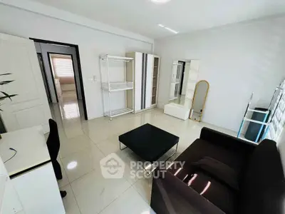 Spacious modern living room with sleek furniture and ample natural light.