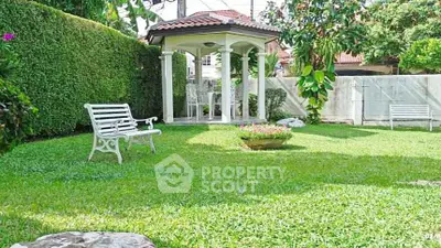 Charming garden with gazebo and benches in a serene residential setting.