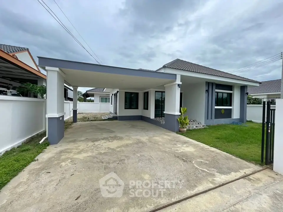 Modern single-story house with spacious driveway and manicured lawn