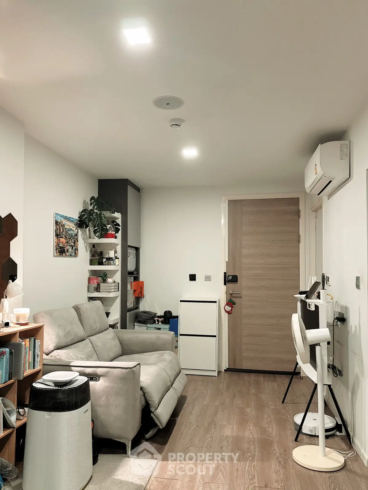 Modern living room with cozy seating and stylish decor in a compact apartment.