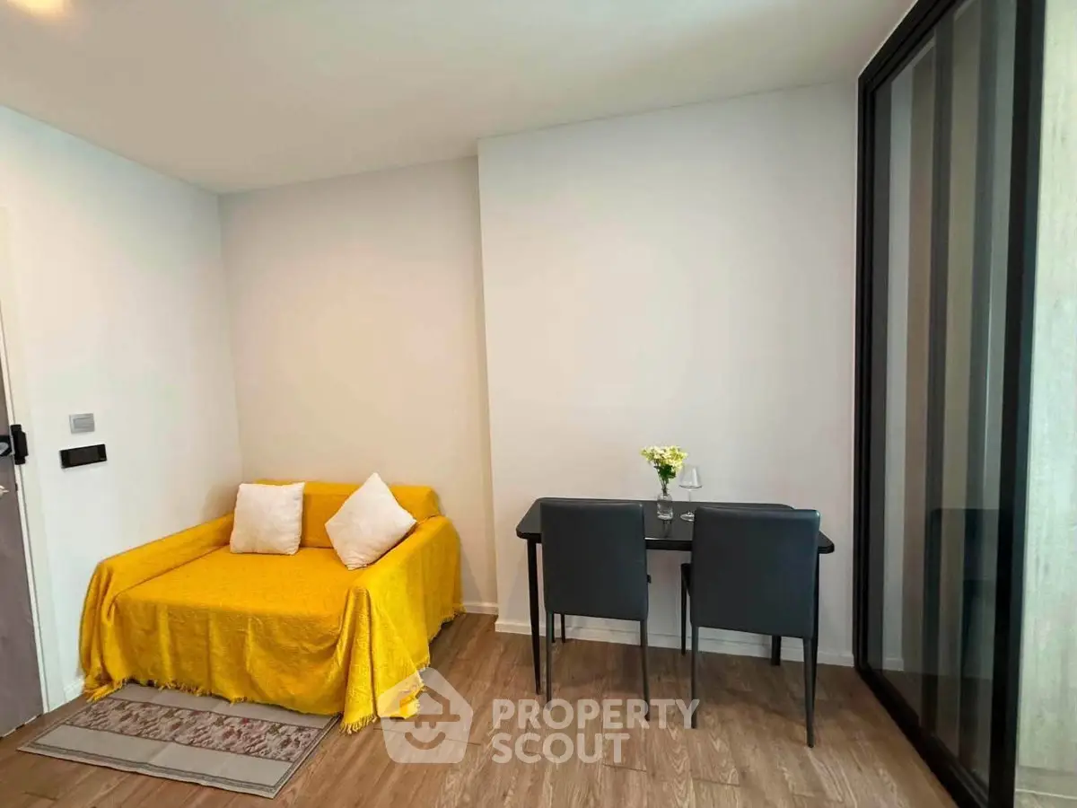 Cozy living room with yellow sofa and dining area in modern apartment