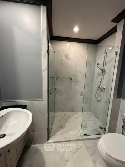 Modern bathroom with glass shower and elegant marble tiles