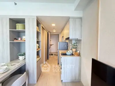 Modern compact kitchen with sleek cabinetry and dining area in stylish apartment