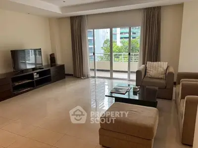 Spacious living room with modern furniture and large windows opening to a balcony.