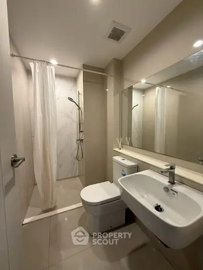 Modern bathroom with sleek fixtures and spacious shower area.