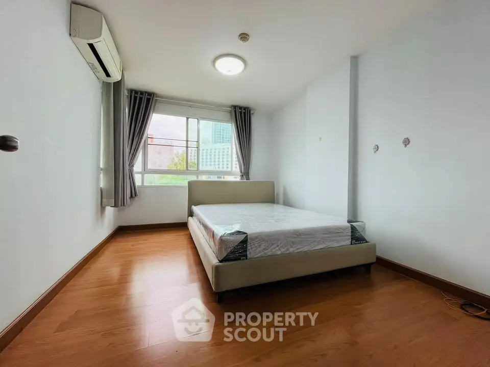 Spacious bedroom with large window and modern air conditioning unit