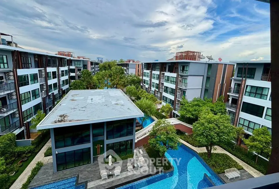 Modern residential complex with lush greenery and inviting swimming pool