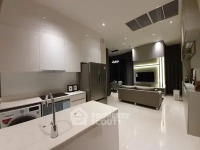 Modern open-plan kitchen and living room with sleek appliances and stylish decor