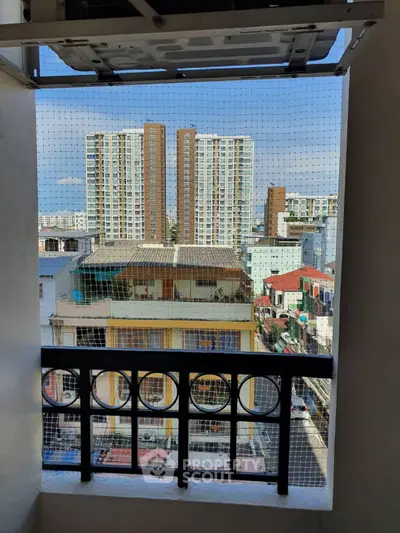 Urban balcony view with high-rise buildings and cityscape in the background.