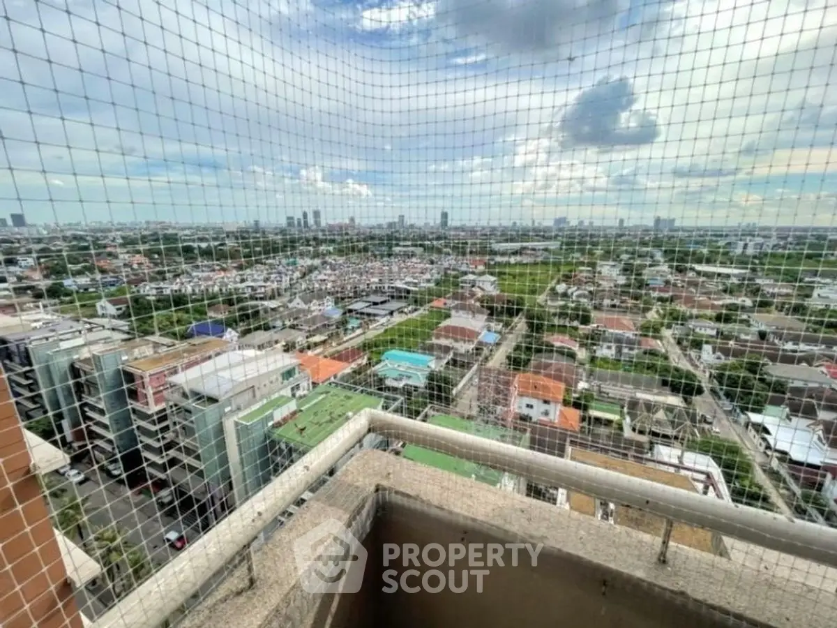 Stunning high-rise balcony view overlooking cityscape and lush greenery.