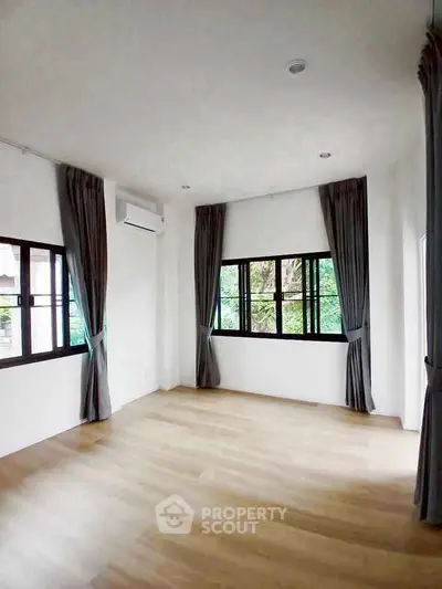 Spacious corner unit with large windows and elegant curtains, offering abundant natural light and serene views.