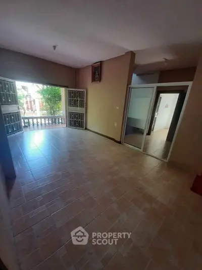 Spacious living room with open balcony and tiled flooring in a modern home.