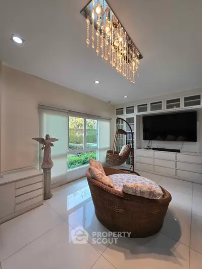 Luxurious living room with elegant chandelier and cozy seating area, perfect for relaxation and entertainment.