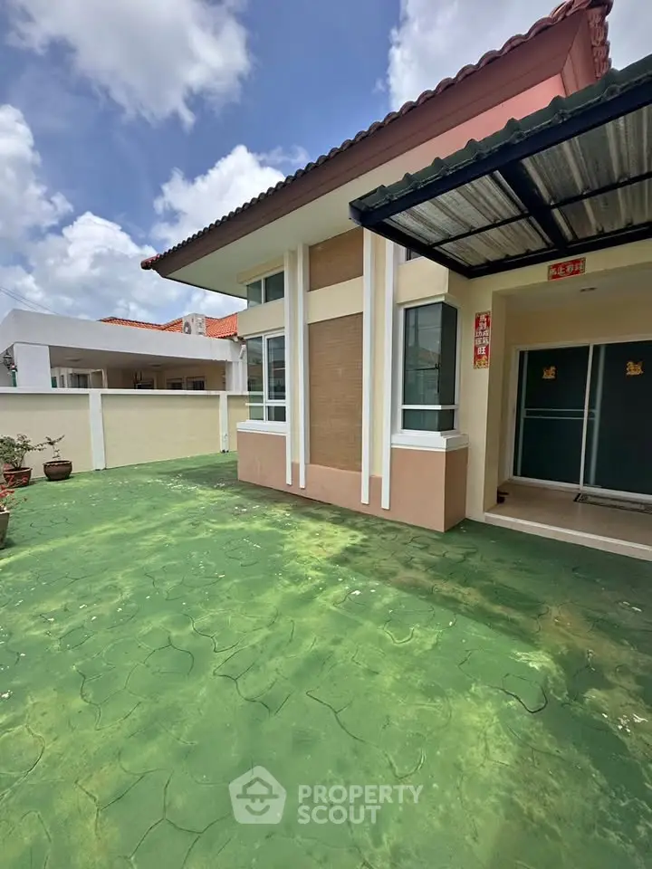 Charming single-story home with spacious green patio and modern exterior design.