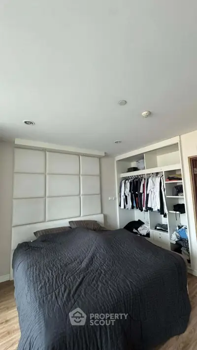 Spacious bedroom with modern built-in wardrobe and cozy bedding in a stylish apartment.