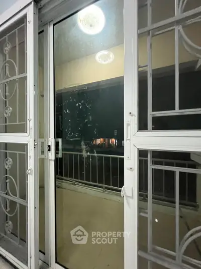Spacious balcony with sliding glass doors and elegant railing, perfect for relaxation.