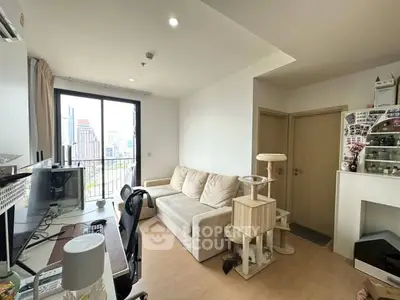 Modern living room with city view, featuring cozy sofa and workspace setup.