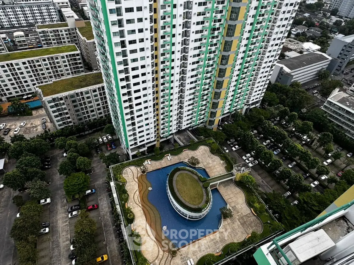 Stunning aerial view of modern high-rise building with pool and lush greenery, perfect urban living.