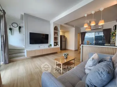 Modern living room with open kitchen, stylish decor, and natural light