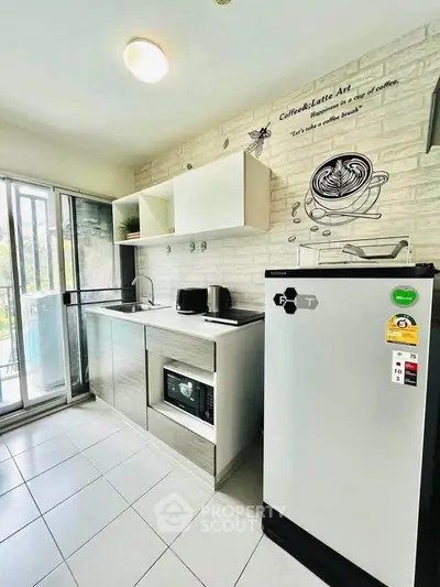Modern kitchen with sleek appliances and open layout, featuring a stylish coffee-themed wall art.