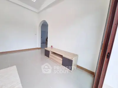 Spacious living room with modern tile flooring and minimalist furniture.
