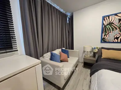 Cozy bedroom with modern decor, featuring a comfortable sofa and stylish artwork.