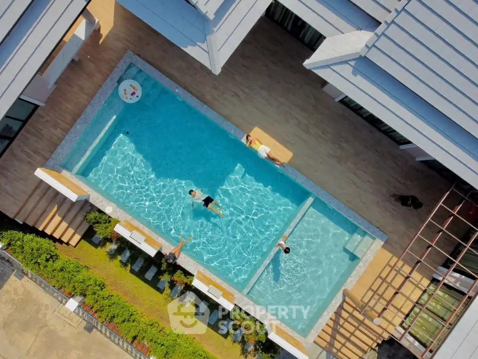 Stunning aerial view of modern residential pool area with sleek design and inviting blue waters.