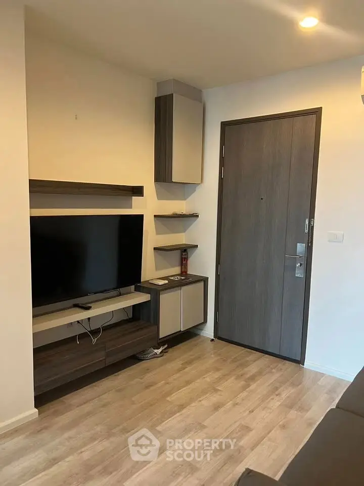 Modern living room with sleek TV unit and wooden flooring, perfect for cozy urban living.