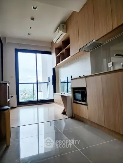 Modern kitchen with open layout and city view from large window.