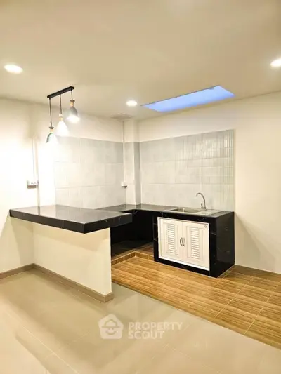 Modern kitchen with sleek black countertops and stylish lighting