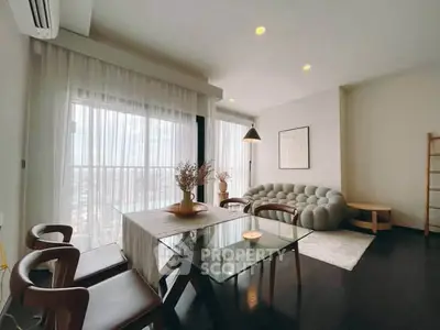 Modern living room with stylish furniture and large windows offering city views.