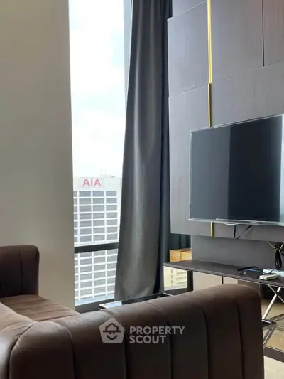 Modern living room with large window and city view, featuring sleek furniture and mounted TV.