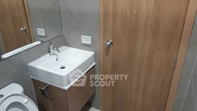 Modern bathroom with sleek sink and wooden accents