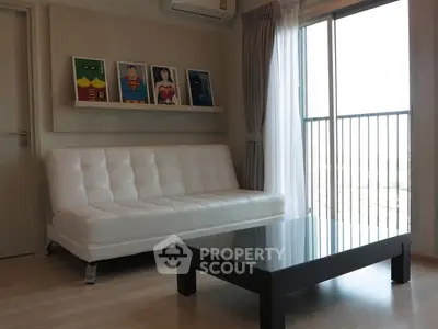 Modern living room with white sofa, glass coffee table, and balcony view.