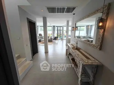 Modern open-plan living room with stylish decor and large windows offering natural light.