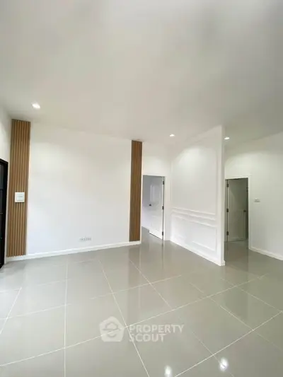 Spacious modern living room with sleek tile flooring and elegant wall accents.