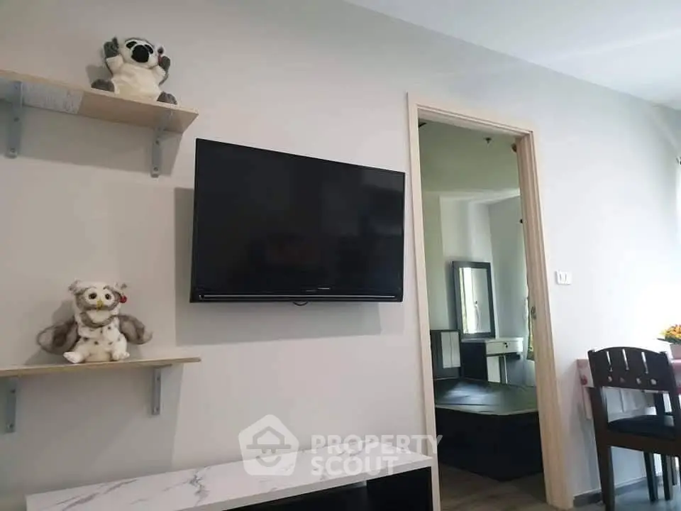 Modern living room with wall-mounted TV and plush toys on shelves