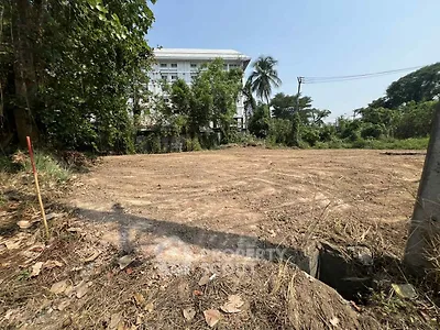 Vacant land plot with lush greenery and potential for development.