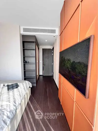 Modern bedroom with stylish orange accent wall and built-in storage
