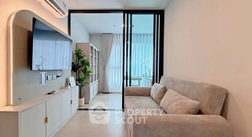 Modern living room with cozy sofa and sleek TV setup, featuring a bright open layout and stylish decor.